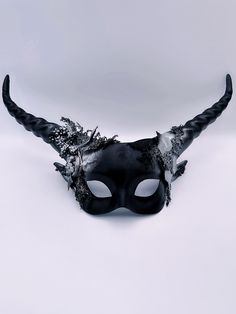 Step into the realm of mystical enchantment with our women's longhorn masquerade mask adorned with a blend of gold and black with forest leaves, Snake and moss. This mask captures the essence of mythical creatures and the allure of nature, infusing your look with a touch of majesty and forest-inspired allure. Age Group/Gender - Adult/Women Size/Type - One size fits all adults Mask Color - Black and gold Mask Material - Polyresin Accent Material - Paint Special Features - Forest leaves and moss Fantasy Horned Masquerade Mask For Costume, Gothic Eye Mask For Fantasy Events, Black Eye Mask For Fantasy Events, Black Horned Mask For Masquerade, Horned Fantasy Masquerade Mask For Halloween, Fantasy Horned Masks For Masquerade, Fantasy Masks For Carnival, Fantasy Eye Mask For Festivals, Fantasy Black Mask For Masquerade