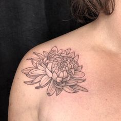 a woman's chest with a flower tattoo on it