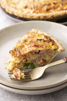 a slice of quiche is on a plate with a fork next to the pie