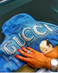 a woman's hand resting on the back of a jean jacket