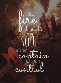 a guitar sitting in front of a campfire with the words fire down in my soul that can't contain control