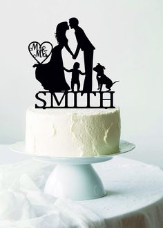 a cake topper that says mr and mrs with two dogs on it, in front of a white background