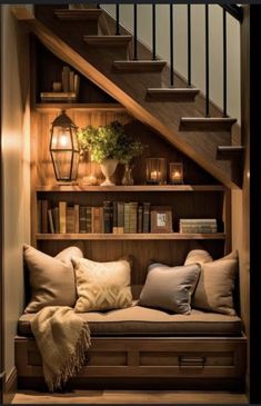 a set of stairs with bookshelves and pillows on the bottom, below it