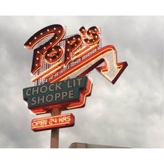 the neon sign for the shoppes is lit up in red and green letters that spell out the store's name