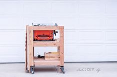 a wooden cart with tools on it in front of a garage door