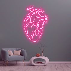 a neon heart wall sticker in a living room with a grey chair and gray walls