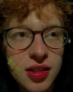 a close up of a person wearing glasses with a toothbrush in their mouth and nose