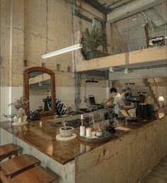 a man working in a commercial kitchen with wooden counter tops and stools around the island