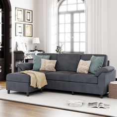 a living room scene with focus on the sectional sofa and throw pillows in front of the window