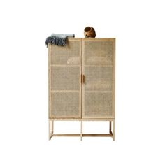 a wicker cabinet with an open door and a hat on it's top