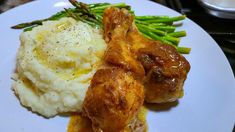 a white plate topped with meat and mashed potatoes