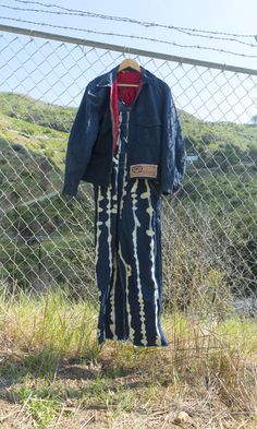 an old coat hanging on a chain link fence