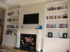 a living room filled with furniture and a flat screen tv mounted on the wall above a fire place