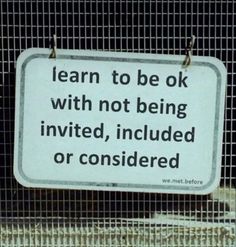 a sign that is attached to a wire fence with words written on the front and back