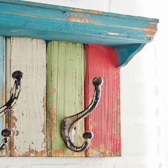 a colorful wooden shelf with hooks on it