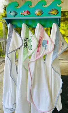 towels hanging from a rack with fish on them