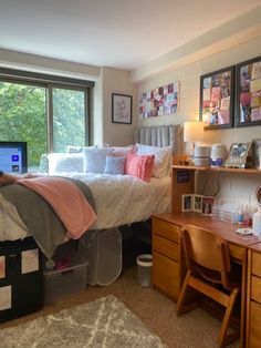 a bed room with a neatly made bed and a laptop on a desk next to a window