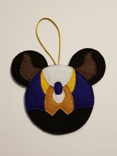 a mickey mouse ornament hanging on a white wall in the shape of a head