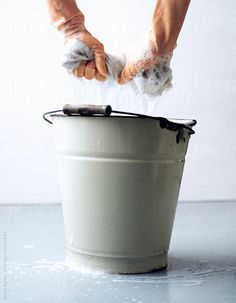 a person is throwing something into a trash can with one hand and the other arm