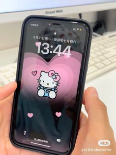 someone is holding up their cell phone with the hello kitty theme on it's screen