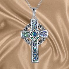 Experience our meticulously handcrafted Celtic Cross Necklace with Star of David, a symbol of unwavering faith, hope, and boundless love. This necklace effortlessly blends simplicity and elegance, making it suitable for every occasion - whether it's daily wear, home, or office. A perfect embodiment of sentiment, this cross necklace is a meaningful gift for your loved ones or yourself. Material Excellence: The cross pendant is crafted from hypoallergenic 925 Sterling silver, ensuring both enduring quality and comfort. Its nickel-free, lead-free, and cadmium-free composition makes it ideal for individuals with sensitive skin. This handcrafted pendant signifies not only beauty but also care for well-being. Size and Details: The Abalone cross pendant measures 1.46 x 0.72 inches (37.2 x 18.3 mm Spiritual Cross Jewelry For Father's Day, Celtic Cross Necklace, Shell Cross, Unwavering Faith, Celtic Knot Pendant, Sterling Silver Cross Necklace, Celtic Cross, Cross Jewelry, Star Of David