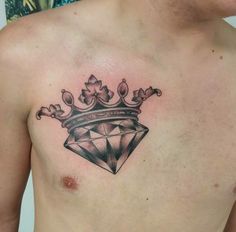 a man's chest with a crown and diamond tattoo on his chest is shown