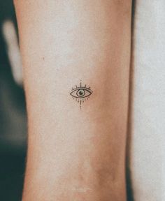 a woman's arm with an eye tattoo on the left side of her body