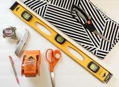 scissors, tape and other items are laid out on a table with the ruler open