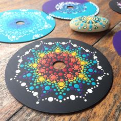 several different colored discs sitting on top of a wooden table next to each other with holes in them