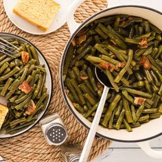 two pans filled with green beans and bacon next to a slice of toasted bread