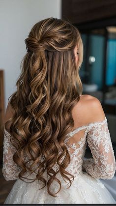 the back of a woman's head with long, wavy hair in her wedding dress