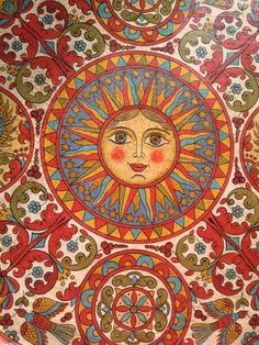 an intricately designed plate with sun and moon designs on it's surface, painted in bright colors