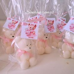 small white teddy bears wrapped in plastic with pink bows and tags on them, sitting next to each other