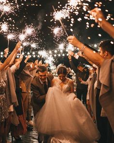 the bride and groom are surrounded by sparklers