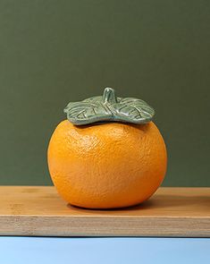 an orange sitting on top of a wooden table