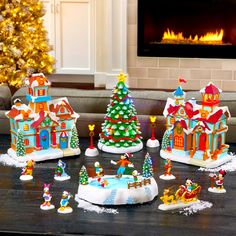 a group of christmas decorations sitting on top of a table next to a fire place