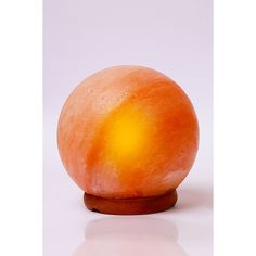 an orange sitting on top of a wooden stand