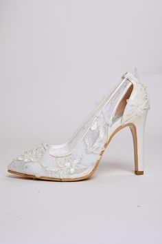 a pair of white wedding shoes with flowers on the heel and lace overlays