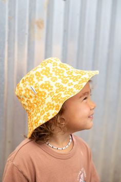 Protect your keiki in style with our Aloha Xchng Kids Puakenikeni Reversible Bucket Hat! With two hats in one, you will find our patch on the solid colored side and our custom Puakenikeni print on the other. Comes with a velcro chin strap to keep on tightly. Sizing: Mini - Newborn - 12 Months Biggie - 1-2 yrs old Designed on Kauai, Hawaii Playful Yellow Hats For Spring, Playful Yellow Hat For Spring, Playful Yellow Spring Hat, Playful Adjustable Reversible Sun Hat, Playful Brimmed Bucket Hat With Upf 50+, Playful Sun Hat With Curved Brim, Playful Yellow Sun Hat For Spring, Yellow Outdoor Hat With Uv Protection, Playful Yellow Wide Brim Sun Hat