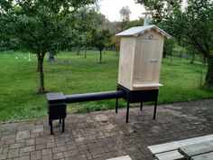 an outhouse and bench in the middle of a park