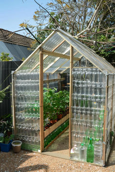 a small greenhouse filled with water bottles and plants