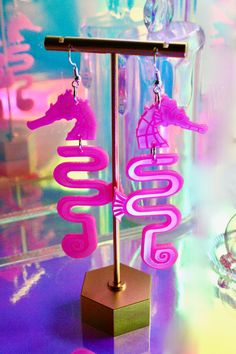 USA-made seahorse earrings! Made of durable acrylic plastic and sterling silver ear hooks. Choose from multiple color options: classic iridescent, mirrored pink, hot pink iridescent, gold, iridescent + mirrored pink. Condition: New. Personally designed, laser-cut, hand-assembled. Measurements: Length: about 3.5" Width: 1.25" Earring Care: Acrylic is extremely lightweight and durable, but can get scratched. To avoid this, please handle your earrings with care! Avoid contact with hairspray, perfume, sweat, and water, wipe clean and store away from direct sunlight. To clean the earrings, wipe with a soft cloth, such as a microfiber material. ♡♡♡♡♡ For store updates, announcements, new products, and fun content, check out my Instagram! https://www.instagram.com/moonstruckdesignspdx/ Seahorse Earrings, Aquarium Water, Pink Head, Pink Iridescent, Water Sea, Mermaid Earrings, Sea Dragon, Pink Body, Sea Horse