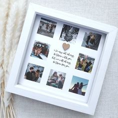 a white frame with pictures and a heart hanging from it's side on a table