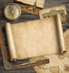 an old map, compass and other items on a wooden table with paper taped to it