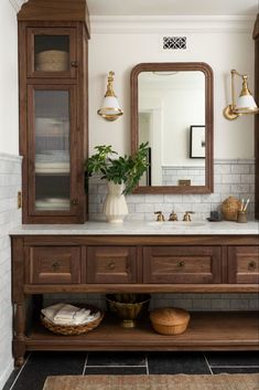 a bathroom with a large mirror, sink and wooden cabinet in the middle of it