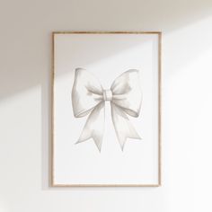 a white bow is hanging on the wall in front of a framed photograph with a wooden frame