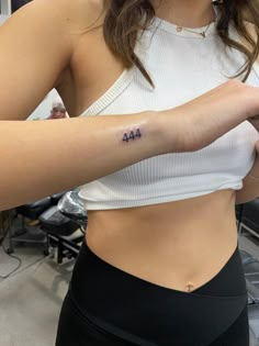 a woman with a small tattoo on her left arm and the number 414 tattooed on her right arm