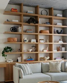 a living room filled with furniture and bookshelves next to a wall covered in shelves