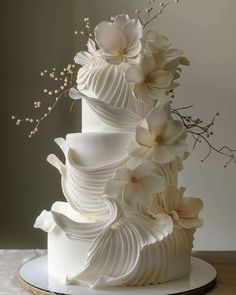 a white wedding cake with flowers on top