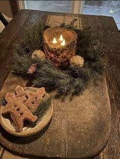 a wooden table topped with cookies and a lit candle